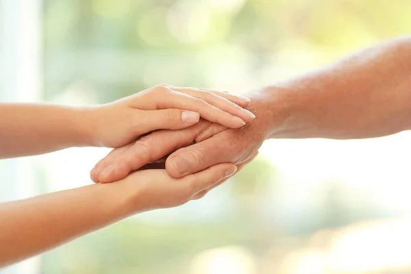 Young Woman Holding Elderly Man Hand Blurred Background Closeup Help — Stock Photo, Image