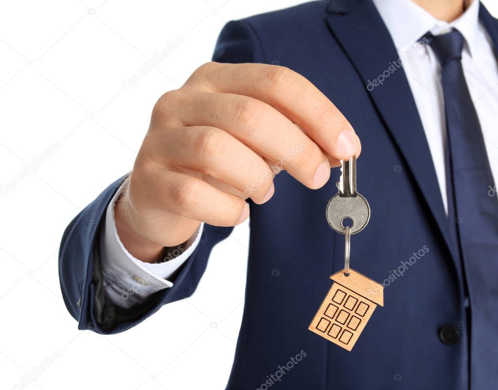Real estate agent holding key on white background, closeup