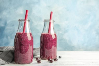 Şişe lezzetli acai smoothie renk arka plan karşı masada ile
