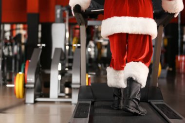 Otantik Noel Baba modern spor salonunda treadmill eğitim, ayak üzerinde odaklanmak