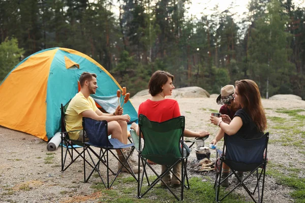 在户外露营帐篷附近与香肠共进午餐的年轻人 — 图库照片