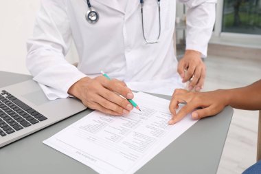 Erkek doktor hasta ile hastane, closeup masada çalışma