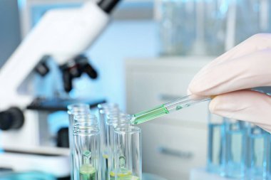 Analist damlama reaktif örnek Laboratuvarı, closeup ile test tüp içine. Kimyasal analiz