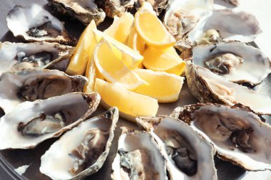 Plaka, closeup üzerinde kesme sulu limonlu taze istiridye