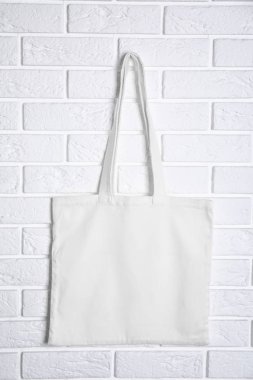 Kadın çantası tuğla duvarda asılı. Tasarım için alay