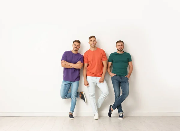 Grupo Hombres Jóvenes Jeans Camisetas Colores Cerca Pared Luz — Foto de Stock