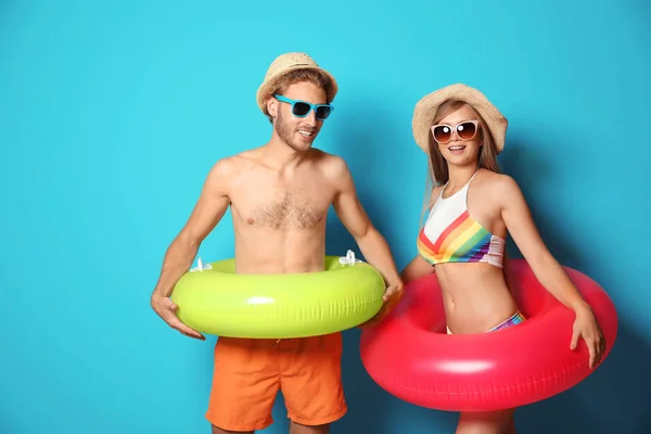 Cuplu Tânăr Costume Plajă Inele Gonflabile Fundal Color — Fotografie, imagine de stoc