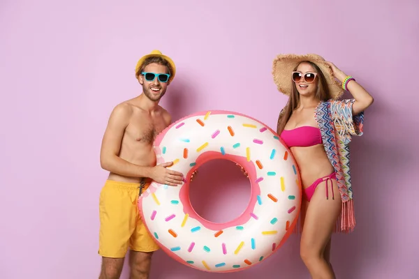 Pareja Joven Ropa Playa Con Anillo Inflable Sobre Fondo Color — Foto de Stock