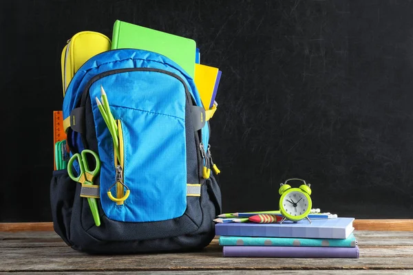 Rugzak Met School Briefpapier Houten Tafel Tegen Blackboard — Stockfoto