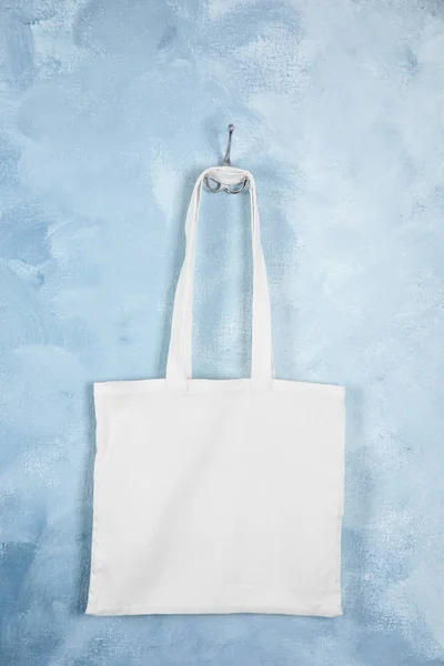 Tote bag hanging on color wall. Mock up for design