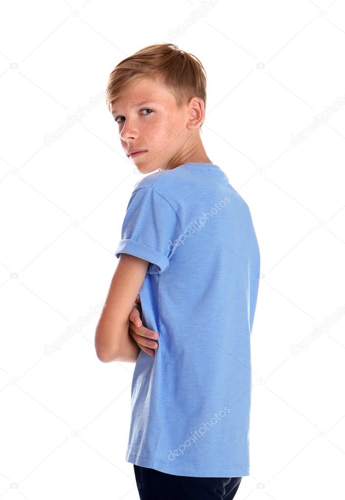 Portrait of young boy standing against white background