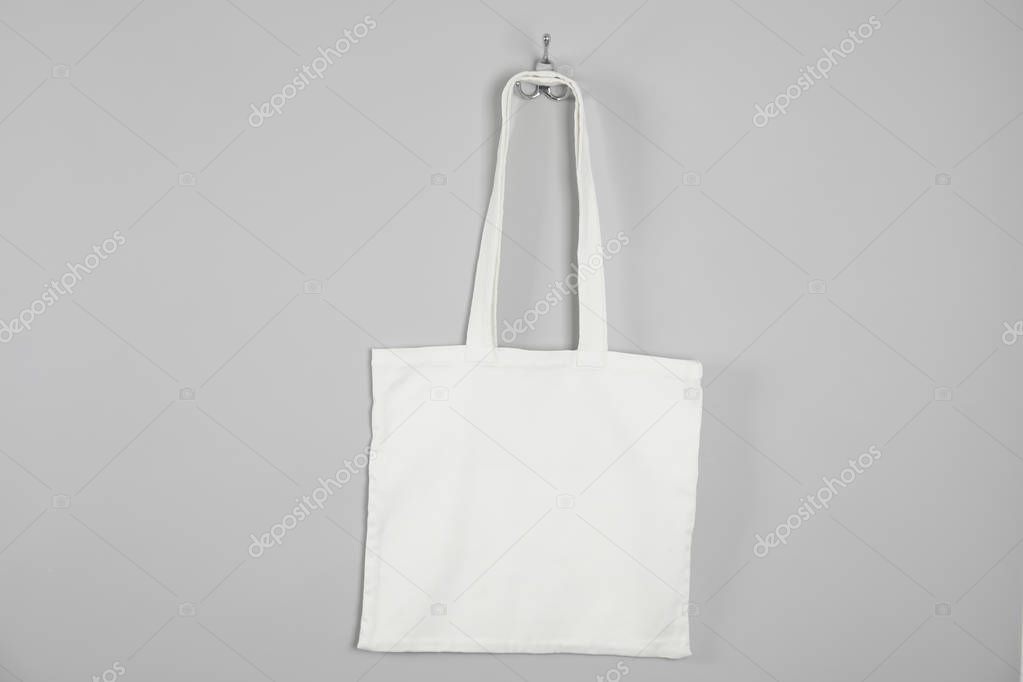 Tote bag hanging on grey wall. Mock up for design