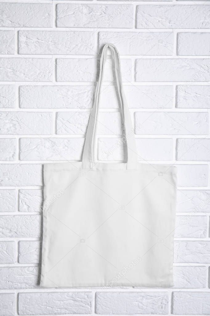 Tote bag hanging on brick wall. Mock up for design