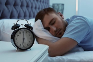 Tablo ve genç adam yatakta gece uyku çalar saat