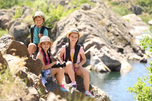 Little children with traveling gear outdoors. Summer camp