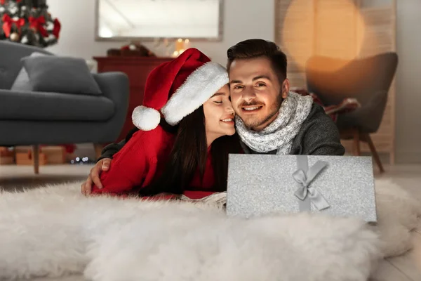 開かれたクリスマス ギフト ボックスを自宅で若いカップルします — ストック写真