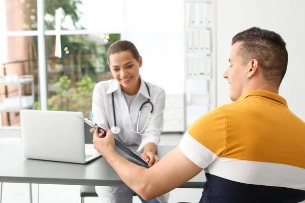 Junger Arzt Berät Patientin Modernem Krankenhaus — Stockfoto