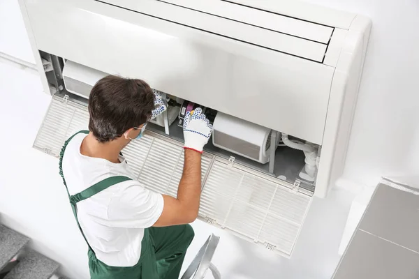 Jeune Technicien Masculin Réparant Climatiseur Intérieur Photos De Stock Libres De Droits