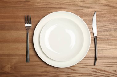Boş dishware ve ahşap arka plan, üstten görünüm üzerinde çatal bıçak takımı. Tablo ayarı