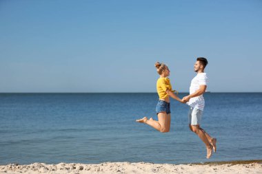 Eğleniyor kumsalda güneşli günde mutlu genç çift