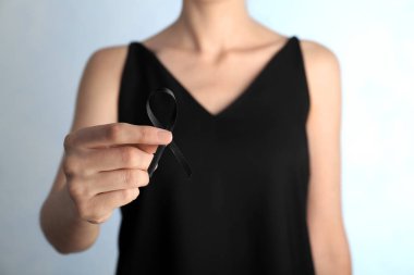 Açık renkli, portre siyah şerit tutan kadın. Cenaze sembolü