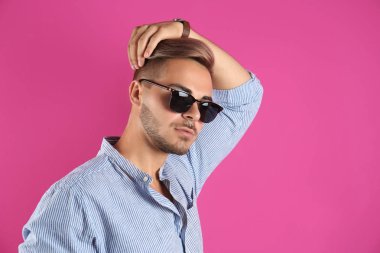 Renk arka plan üzerinde son moda saç modeli ile genç adam