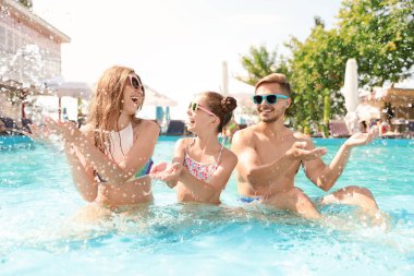 Mutlu aile eğleniyor havuzda güneşli günde