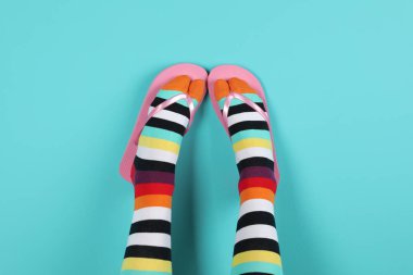 Renk arka plan üzerinde parmak arası terlik ile parlak çorap giyen kadın