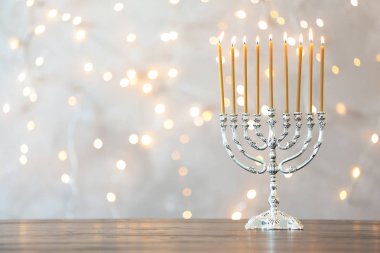 Hanukkah menorah bulanık ışıklar karşı masada mumlarla