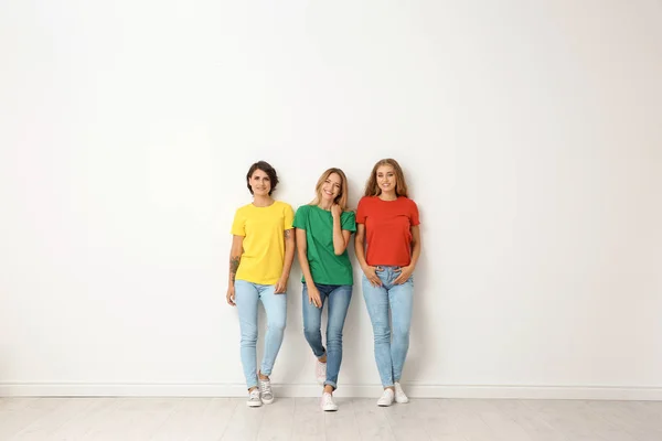 Grupo Mujeres Jóvenes Jeans Camisetas Colores Cerca Pared Luz — Foto de Stock