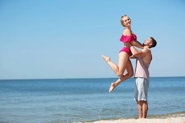 快乐的年轻夫妇在海滩上享受阳光明媚的一天 — 图库照片
