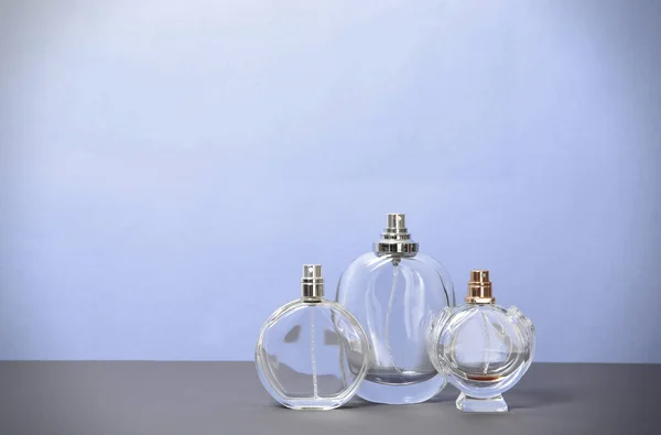 Frascos Perfume Diferentes Mesa Contra Fondo Color —  Fotos de Stock