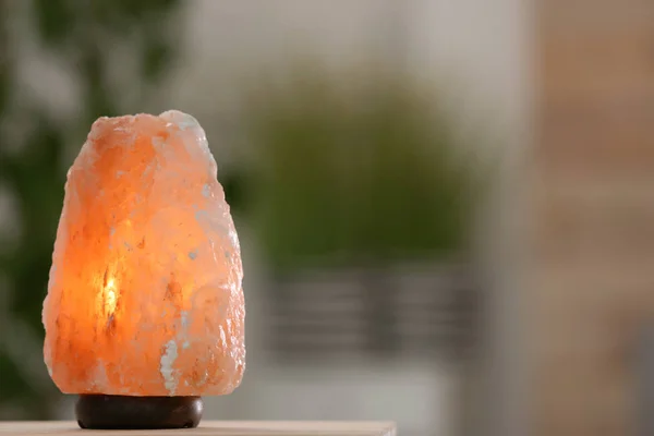 Himalayan salt lamp on table against blurred background