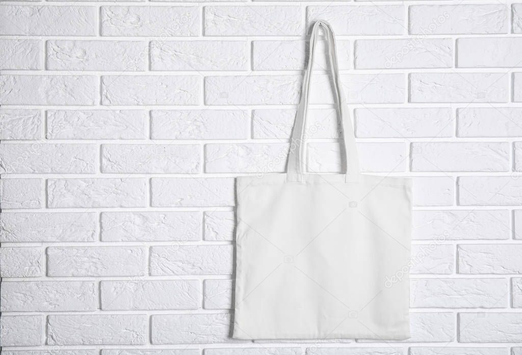 Tote bag hanging on brick wall. Mock up for design