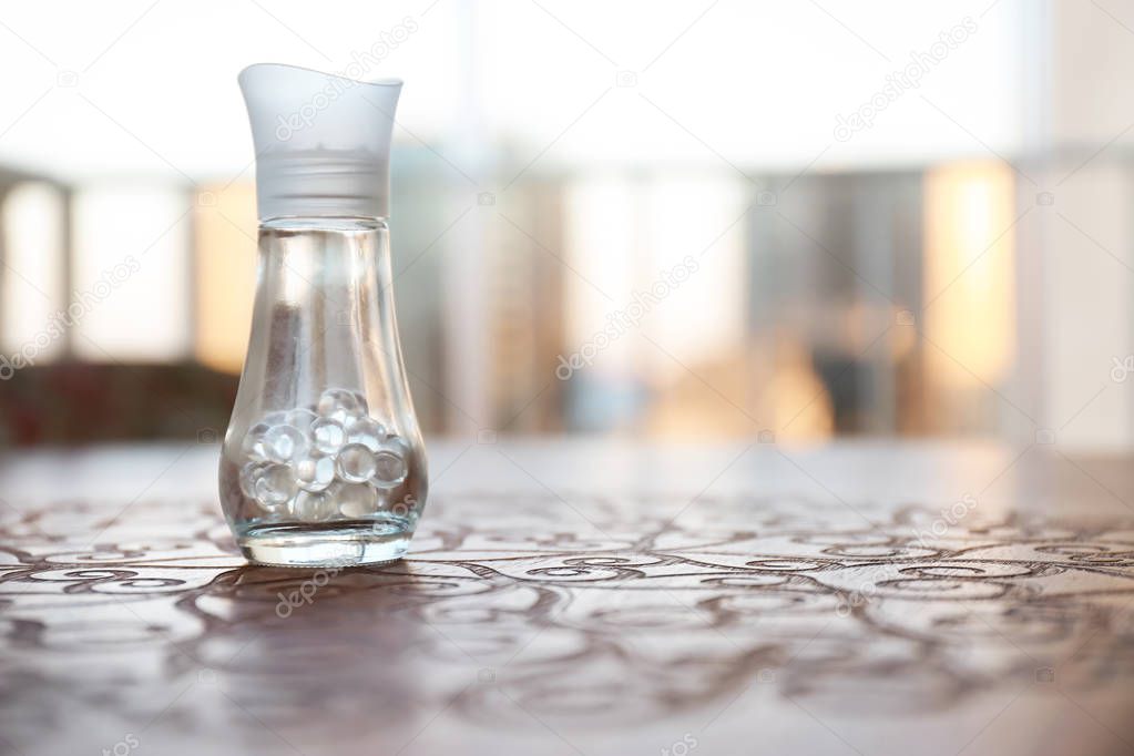 Air freshener on wooden table against blurred background