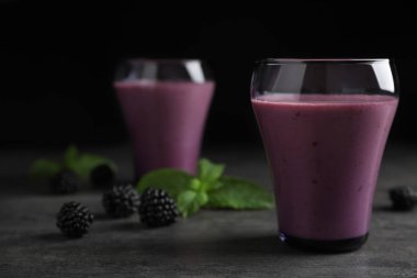 Blackberry yoğurt smoothies koyu arka plan gri masada ile gözlük