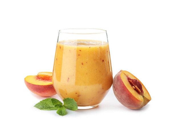 Tasty peach smoothie in glass and fresh fruit on white background