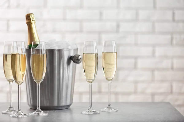 Brýle Šampaňským Láhev Kbelíku Stole Proti Cihlové Zdi — Stock fotografie