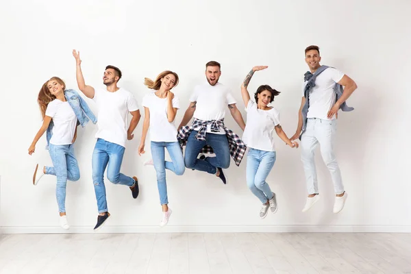 Grupo Jovens Jeans Pulando Perto Parede Leve — Fotografia de Stock