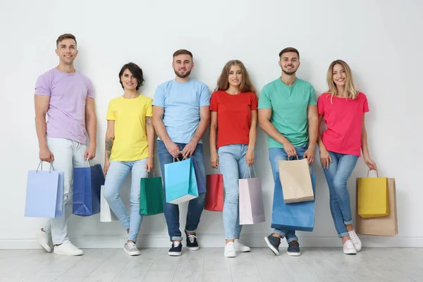 Gruppo Giovani Con Shopping Bag Vicino Alla Parete Luminosa — Foto Stock