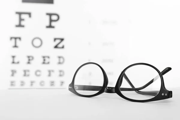 Óculos Com Lentes Corretivas Mesa Contra Gráfico Ocular — Fotografia de Stock