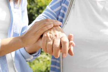 Bulanık arka planda ellere yardım etmek, yakın çekim. Yaşlılara bakım kavramı