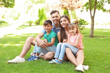 Park yeşil çimenlerin üzerinde şirin çocuk annesiyle. Mutlu bir aile