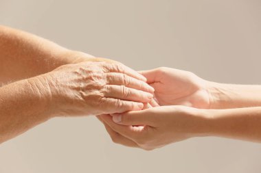 Bulanık arka planda ellere yardım etmek, yakın çekim. Yaşlılara bakım kavramı