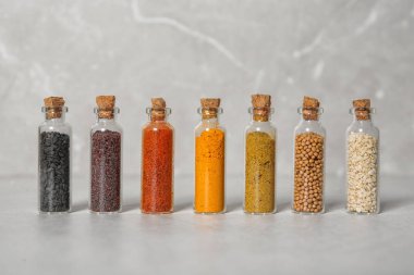 Satır renk arka plan üzerinde farklı baharatlar ile küçük cam şişe