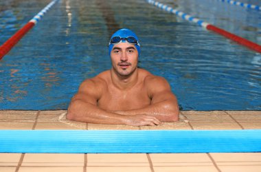Kap ve gözlük yüzme havuzunda giyen genç atletik adam