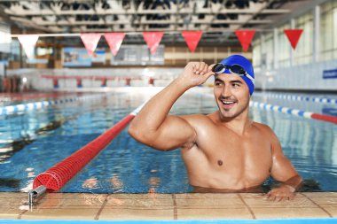 Kap ve gözlük yüzme havuzunda giyen genç atletik adam