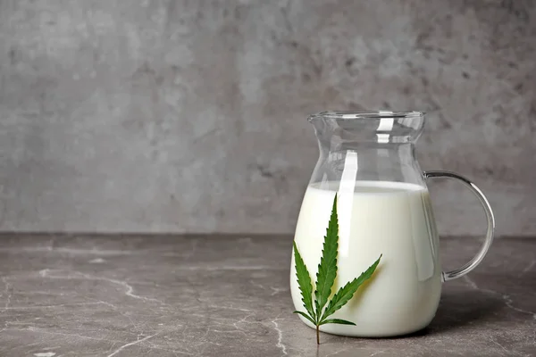 Pitcher of hemp milk on grey table