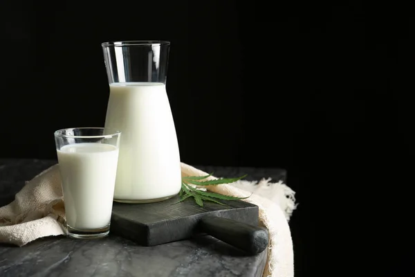 Composition with hemp milk on table against black background