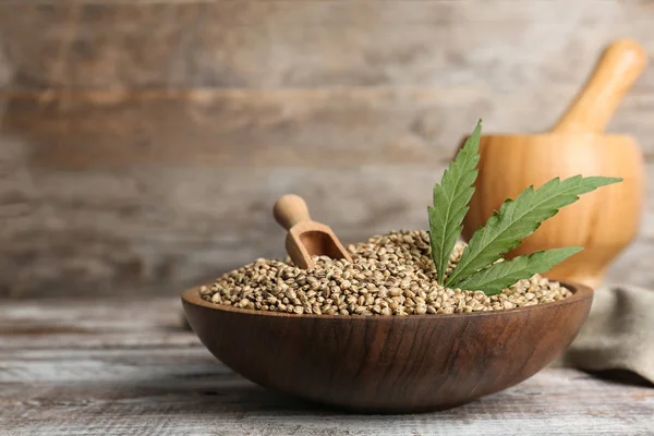 Kenevir tohumu ahşap duvar karşı masada kase